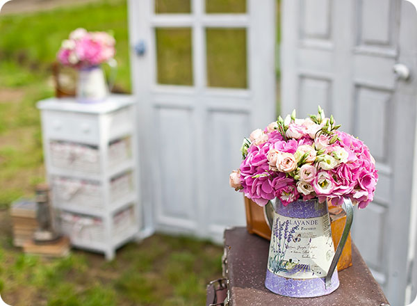 Photo shows a set of white rustic doors, styled for a wedding ceremony backdrop